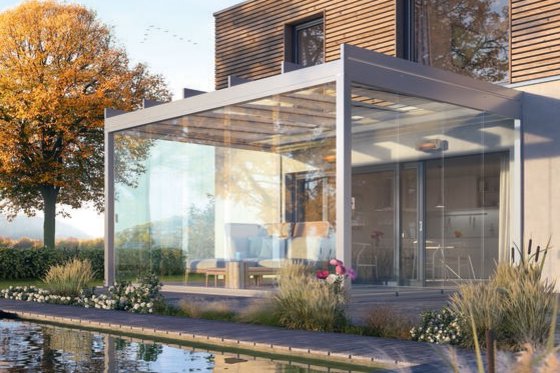 Moderne Überdachung aus Glas und Metall mit Terrassensituation und angrenzendem Wasserbereich, umgeben von Pflanzen. Moderne Überdachung aus Glas und Metall mit Terrassensituation und angrenzendem Wasserbereich, umgeben von Pflanzen.