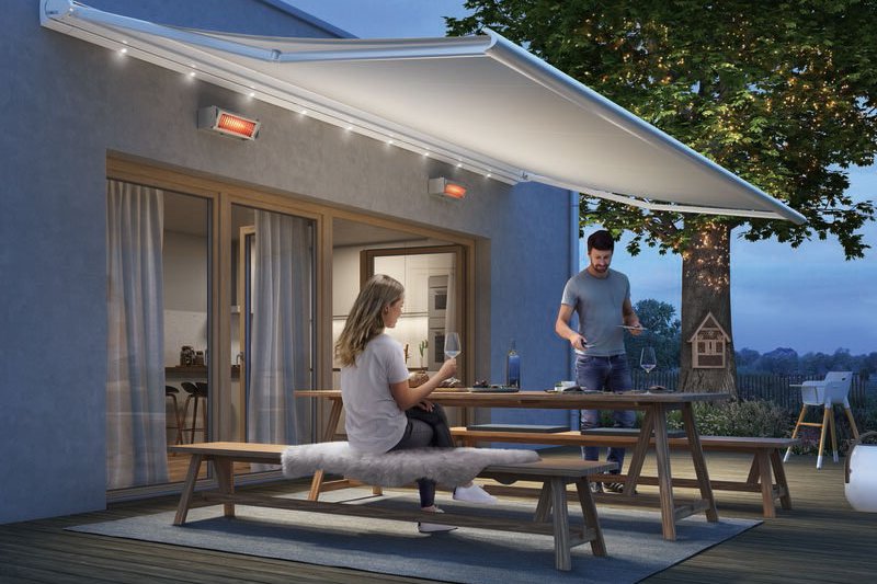 Eine Familie genießt den Abend unter einer Markise auf der Terrasse. Sanftes Licht und gemütliche Atmosphäre. Eine Familie genießt den Abend unter einer Markise auf der Terrasse. Sanftes Licht und gemütliche Atmosphäre.