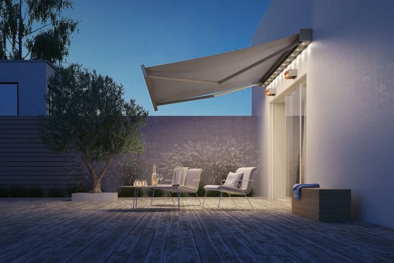Sonnenmarkise in einem modernen Terrassensituation mit Holzfußboden und Bäumen im Hintergrund. Sonnenmarkise in einem modernen Terrassensituation mit Holzfußboden und Bäumen im Hintergrund.