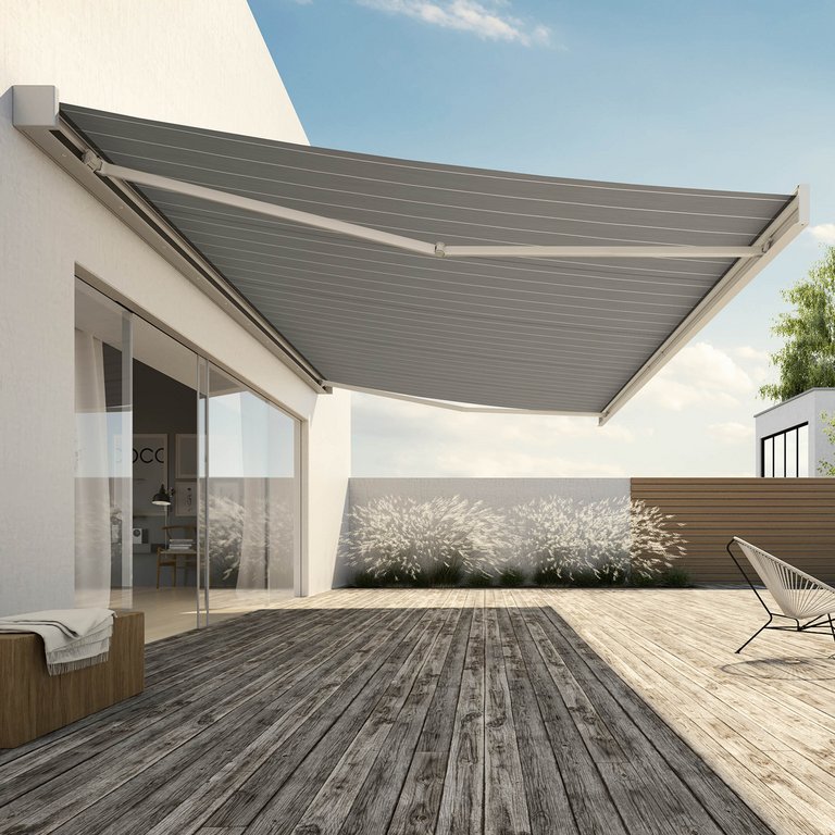 Markise in hellem, gerilltem Design über einer Terrassensituation mit Holzdielen und modernen Möbeln.