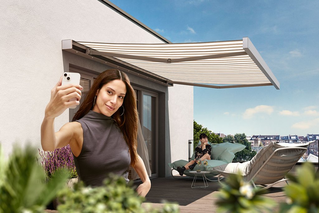 Eine Person macht ein Selfie auf einer Terrasse, im Hintergrund eine Markise und Pflanzen. Himmel mit Wolken. Eine Person macht ein Selfie auf einer Terrasse, im Hintergrund eine Markise und Pflanzen. Himmel mit Wolken.