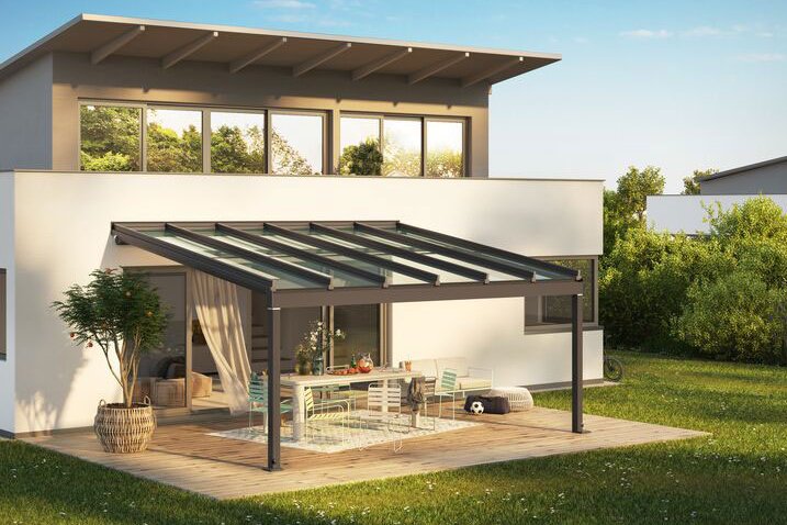Moderne Überdachung mit Glas-Schiebewänden und Terrassensituation in grünem Garten. Moderne Überdachung mit Glas-Schiebewänden und Terrassensituation in grünem Garten.