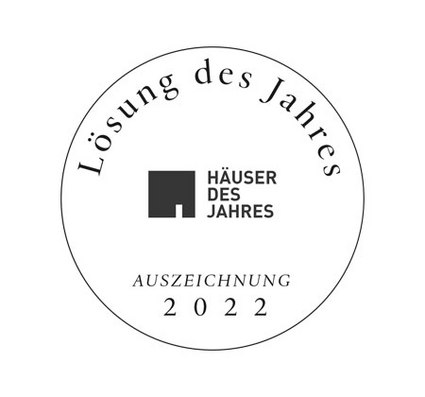 Logoelement mit dem Text "Lösung des Jahres" und "Häuser des Jahres", umgeben von einem runden Rand.