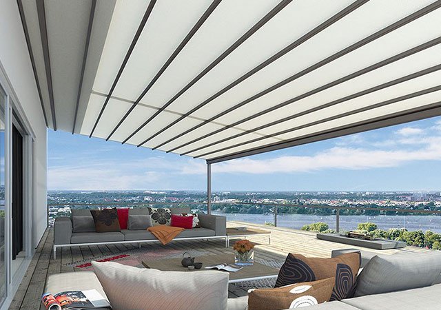 Terrassensituation mit Markise und Blick auf eine Landschaft, moderne Möbel und helle Farben.